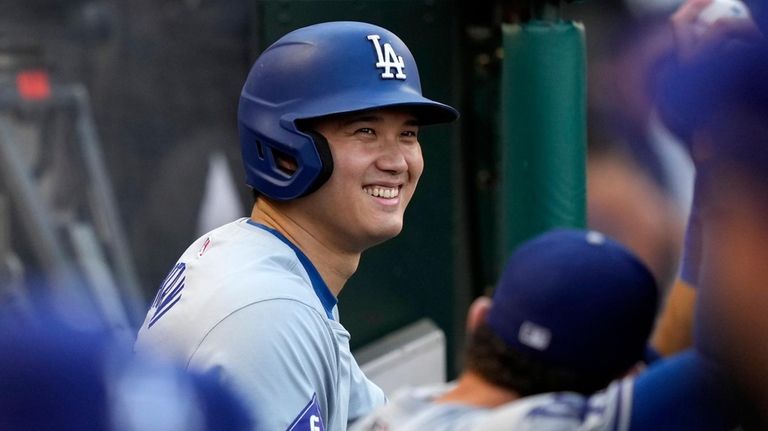 Los Angeles Dodgers' Shohei Ohtani smiles in the dugout prior...