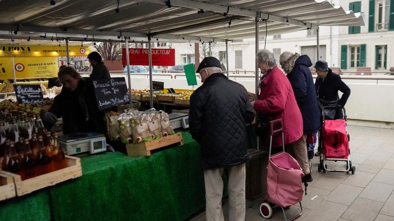 People shop at an open air market in Fontainebleau, south...