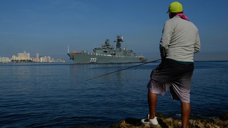 A fisherman watches the patrol boat "Neustrahimiy" arrive for a...