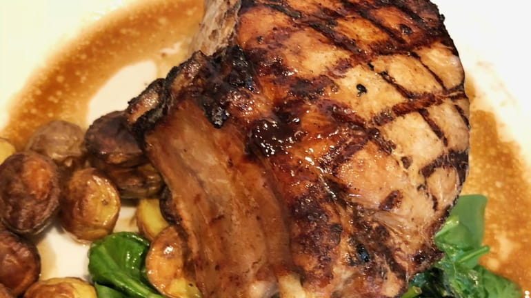 A double-cut pork chop served with sautéed broccoli rabe at...