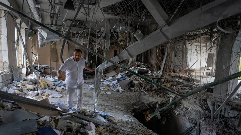 Alya Gali, a Gaza Strip-born doctor, looks at debris two...