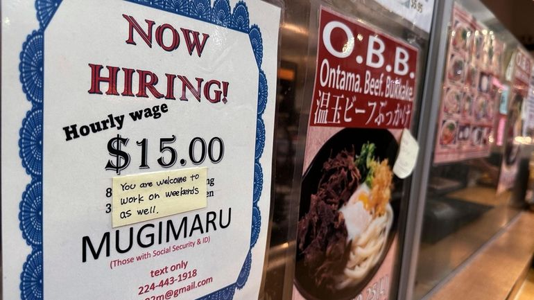 A hiring sign is displayed at a restaurant in Arlington...