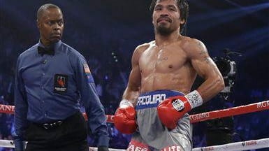 Manny Pacquiao lifts his trunks after being knocked down in...