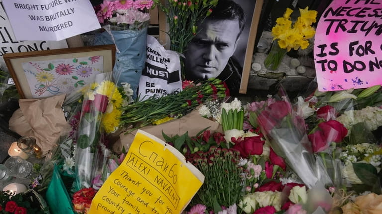 Flowers and portraits are left opposite the Russian embassy, to...