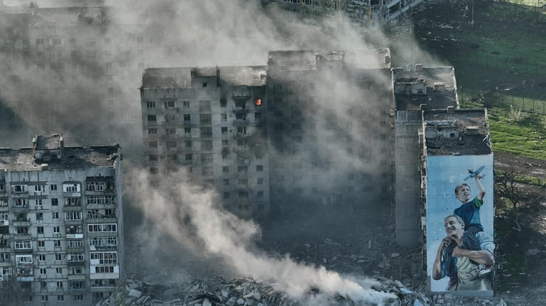 Smoke rises from a building in Bakhmut, the site of...