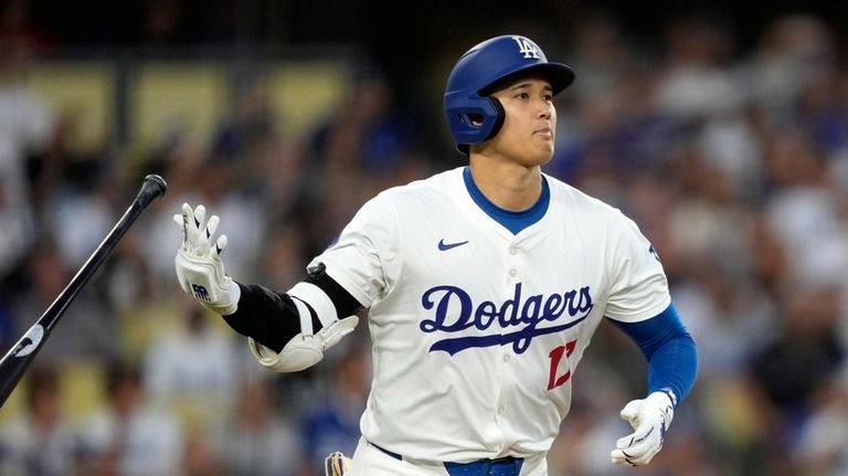 Los Angeles Dodgers' Shohei Ohtani drops his bat as he...