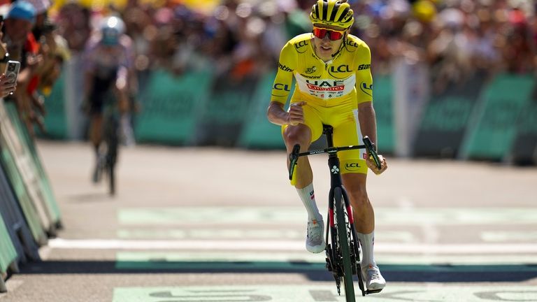 Slovenia's Tadej Pogacar, wearing the overall leader's yellow jersey, extended...