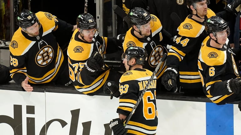 Boston Bruins' Brad Marchand (63) celebrates with teammates after scoring...