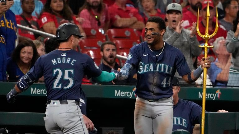 Seattle Mariners' Dylan Moore (25) is congratulated by teammate Julio...