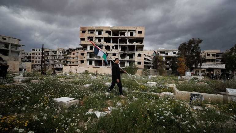 A man carries Palestinian flag in a Palestinian refugee camp...
