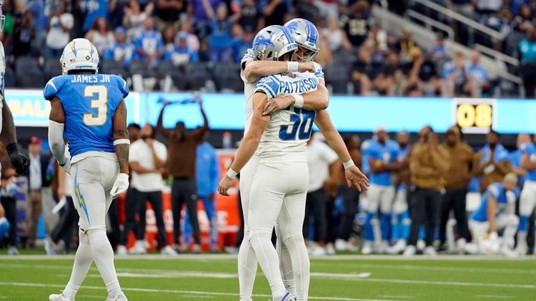 Detroit Lions place kicker Riley Patterson (36) is hugged by...