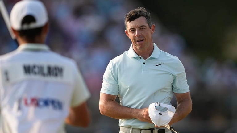 Rory McIlroy, of Northern Ireland, reacts after missing a putt...