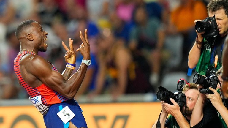 Grant Holloway, of the United States celebrates after winning the...