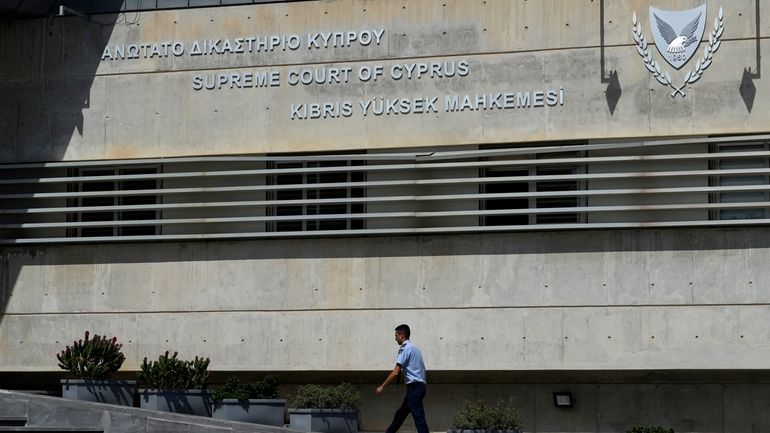 A Cypriot police officer walks outside from the Cyprus' Supreme...