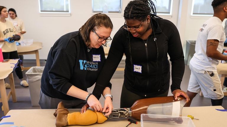 Kaitlin Deegan of Levittown, left, and Sienna Burnett of Rosedale, Queens, disassemble...