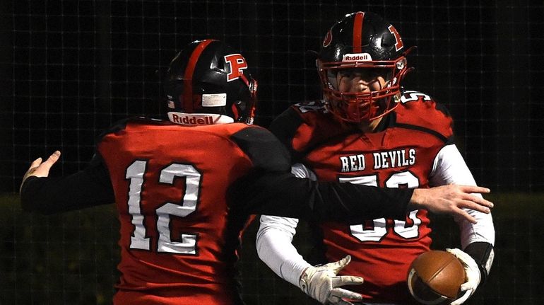 Anthony Morello #56 of Plainedge, right, gets congratulated by teammate...