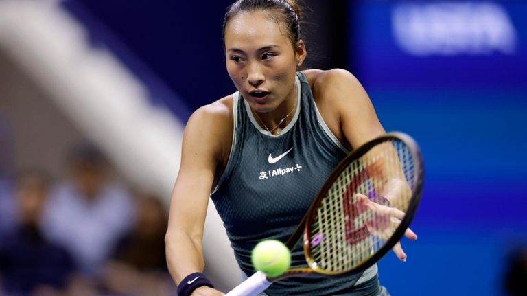 Zheng Qinwen, of China, returns a shot to Donna Veki,...