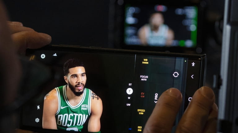 Boston Celtics' Jayson Tatum speaks on a television monitor during...