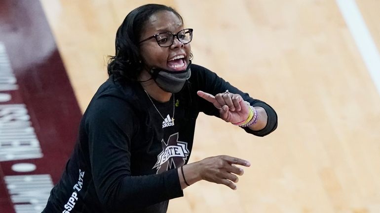 Mississippi State coach Nikki McCray-Penson lowers her mask as she...