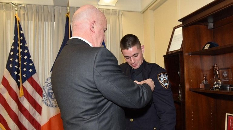 NYPD Commissioner James P. O'Neill pins the badge of James...