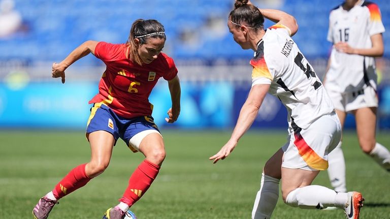 Spain's Aitana Bonmati, left, challenges for the ball with Germany's...