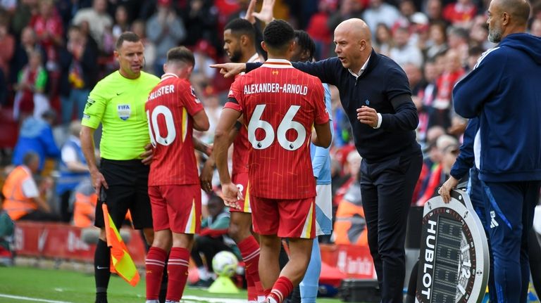 Liverpool's Trent Alexander-Arnold, center, receives instructions by his manager Arne...