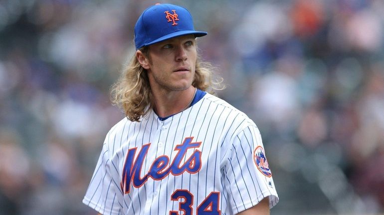 Mets starting pitcher Noah Syndergaard walks to the dugout after...