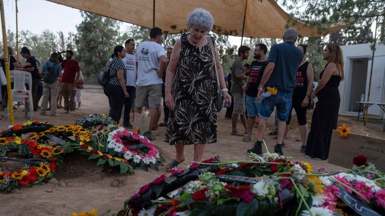 Widow Ruti Munder stands near the grave of her husband...