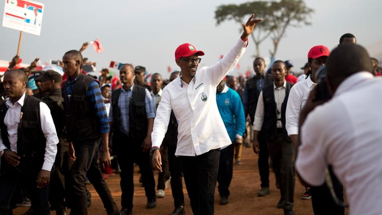 Rwanda's President Paul Kagame wave as he leaves an election...