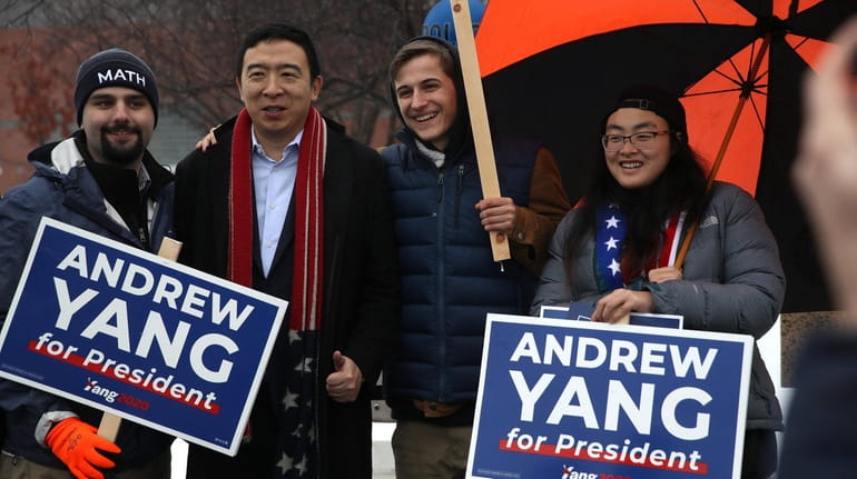 Democratic presidential candidate Andrew Yang taks a photo with supporters...