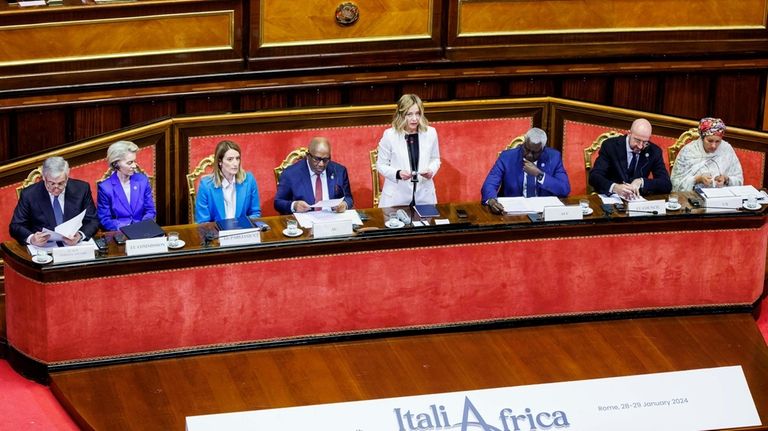 Italian Premier Giorgia Meloni, center, speaks as she is flanked...