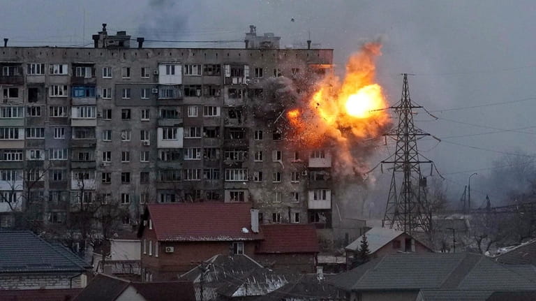 An explosion erupts from an apartment building after a Russian...