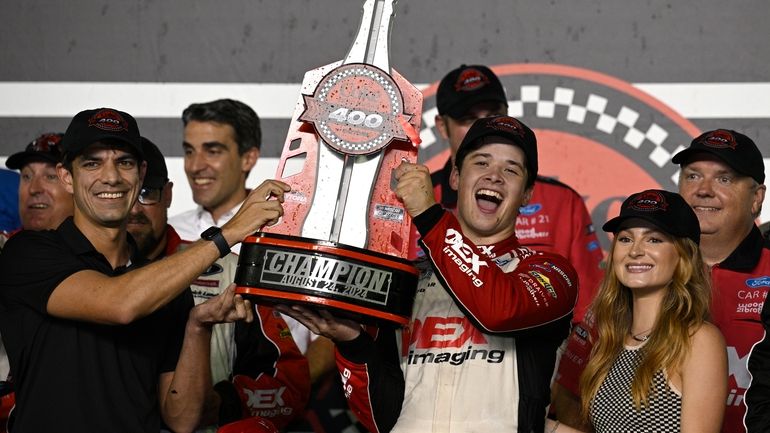 Harrison Burton, center right, celebrates with the championship trophy after...