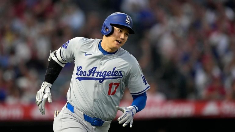 Los Angeles Dodgers' Shohei Ohtani heads to first for an...