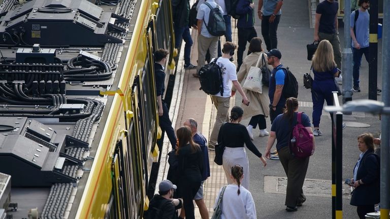 Commuter disembark a Great Northern railway train at Hunt's Cross...