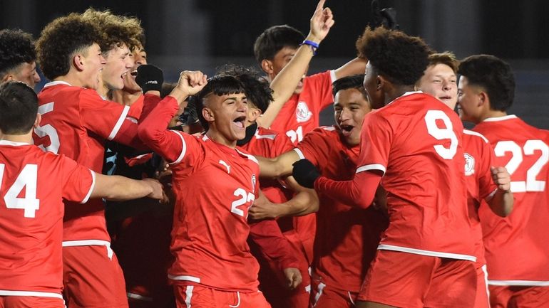 Jose Escobar (#27, right arm raised) and his Mineola teammates...