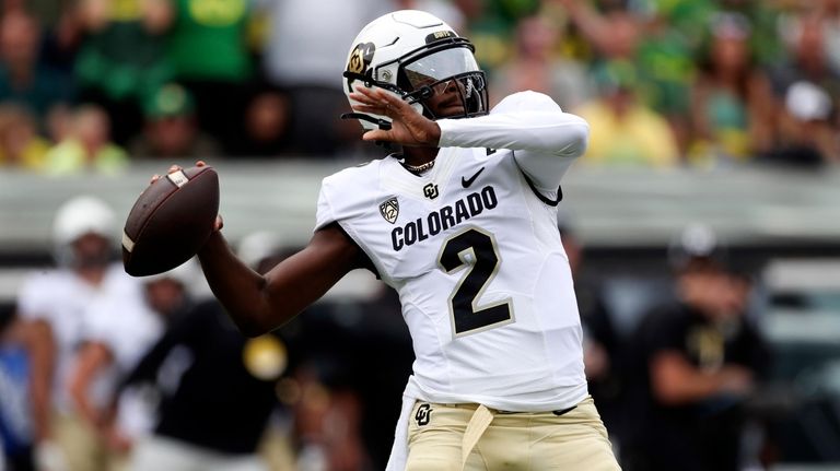 Colorado quarterback Shedeur Sanders reaches back to pass against Oregon...