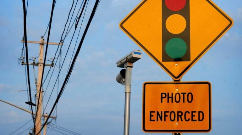 A sign and red-light camera on Middle Country Road.
