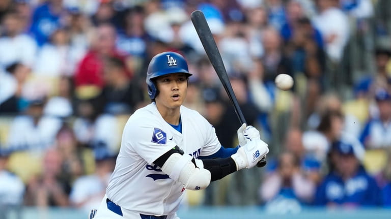 Los Angeles Dodgers designated hitter Shohei Ohtani reacts to a...