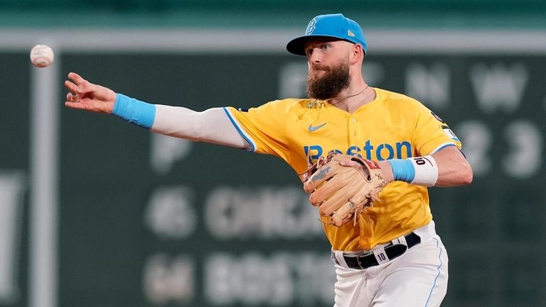 Boston Red Sox shortstop Trevor Story throws to first base...