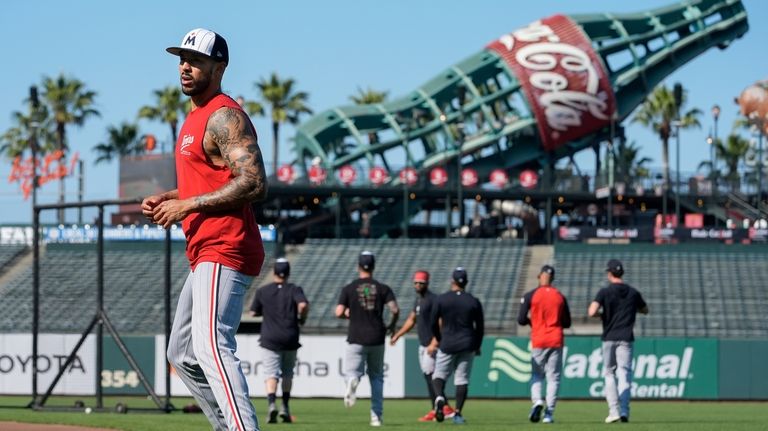 Minnesota Twins' Carlos Correa, left, warms up before a baseball...