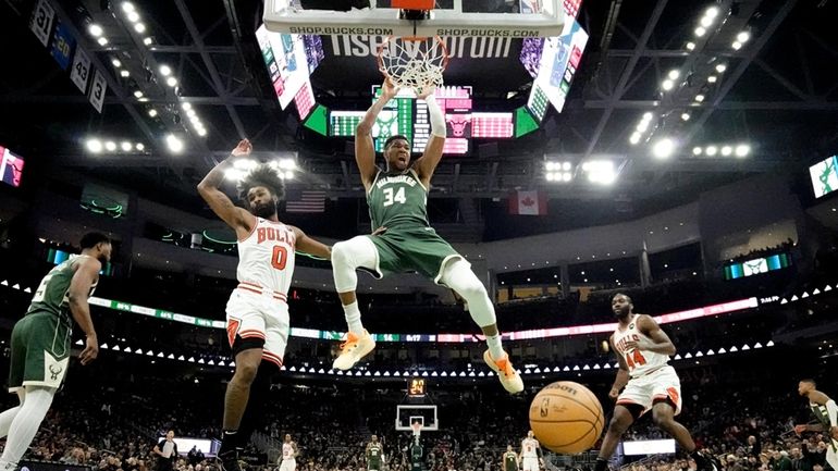 Milwaukee Bucks' Giannis Antetokounmpo dunks over Chicago Bulls' Coby White...