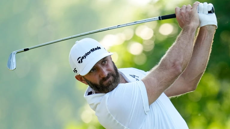 Dustin Johnson watches his tee shot on the 11th hole...
