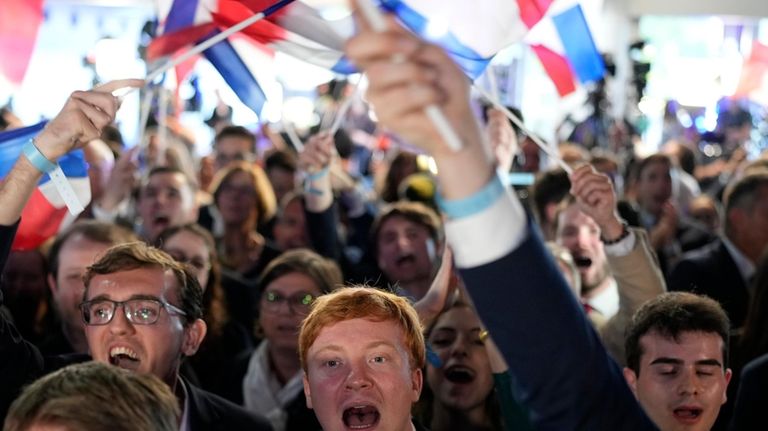 Supporters of French far-right National Rally react at the party...