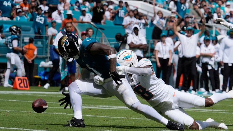 Miami Dolphins safety Jevon Holland (8) grabs Jacksonville Jaguars running...