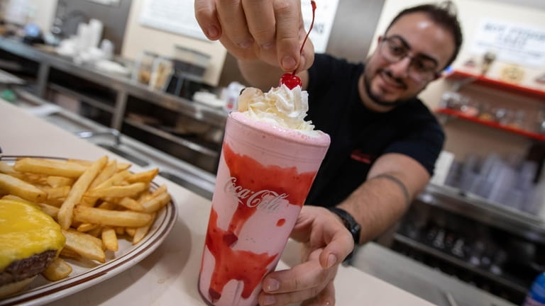 Salvatore Mangano makes a strawberry milkshake at Henry’s Confectionery in...