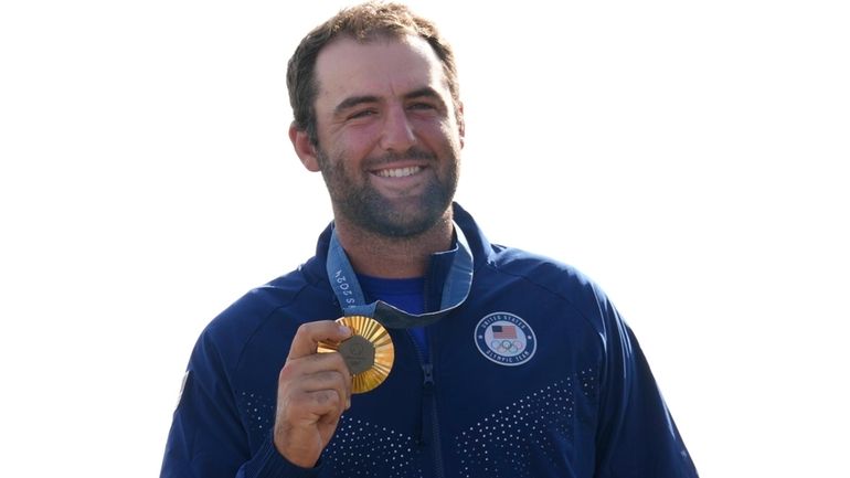 Gold medalist Scottie Scheffler, of the United States, poses with...