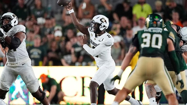 Colorado quarterback Shedeur Sanders, left, throws a pass as Colorado...