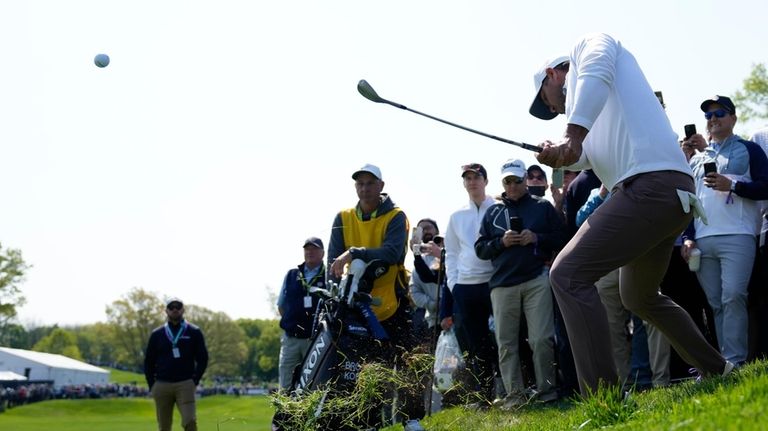 Brooks Koepka hits from the rough on the 11th hole...