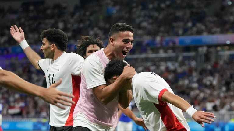 Egypt's Mahmoud Saber, right, is congratulated by teammates after scoring...